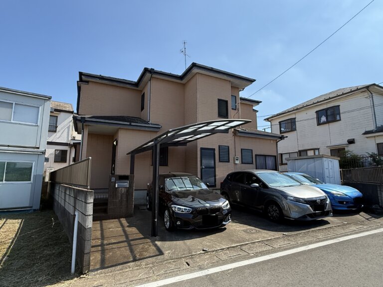 さいたま市見沼区の中古戸建ての外観。晴れた日の東南角地の様子で、3台分の駐車スペースも写っている。