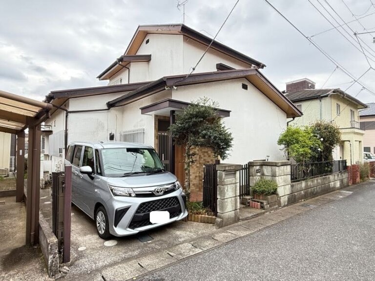 千葉市中央区赤井町の売地の現況写真。解体予定の既存建物（戸建て）の外観と、駐車スペースに停められた車が写っている。