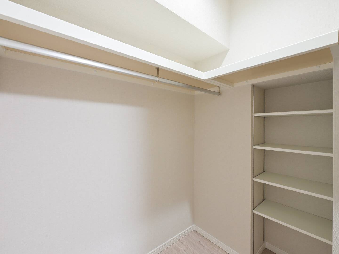 ウォークインクローゼットの内部。ハンガーパイプと上部棚に加え、可動式の棚も設置されており、衣類から小物まで無駄なくたっぷり収納できる造りになっている。